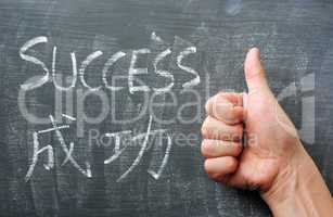 Success - word written on a blackboard with a Chinese translation