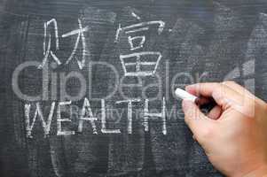 Wealth - word written on a blackboard with a Chinese version