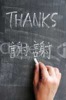 Thanks - word written on a blackboard with a Chinese version