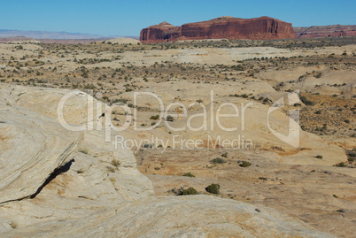 High above Secret Spire with white and red rocks under blue sky, Utah