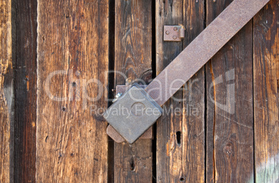 Old padlock on a wooden door