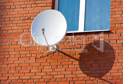 Satellite Dish mounted on  brick wall.