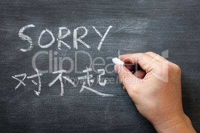 Sorry - word written on a smudged blackboard