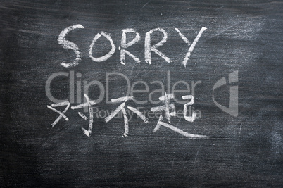 Sorry - word written on a smudged blackboard