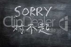 Sorry - word written on a smudged blackboard