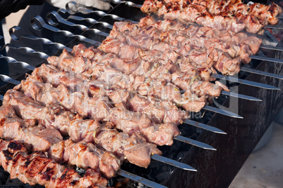 Juicy slices of meat with sauce prepare on fire (shish kebab).