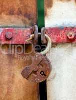 Rusty padlock on an old metal door