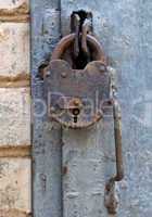 Rusty padlock on an old metal door