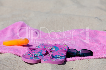 Badelatschen auf dem Handtuch am Sandstrand