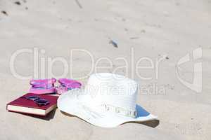 Entspannt am Badestrand mit Buch und Strohhut