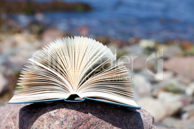 Aufgeschlagenes Buch liegt am Strand