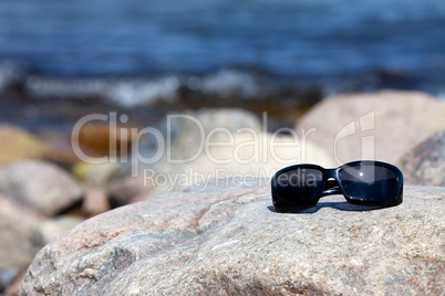 Moderne Sonnenbrille auf grossem Felsen