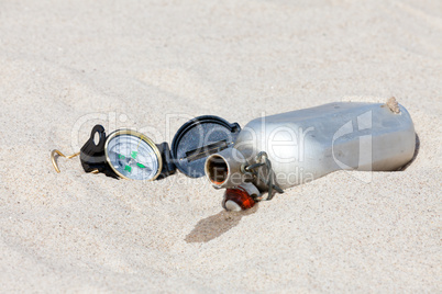 Aus der Feldflasche sickert Wasser in den Sand