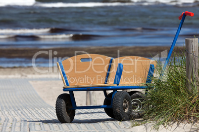 Bollerwagen steht allein am Wegesrand zum Strand