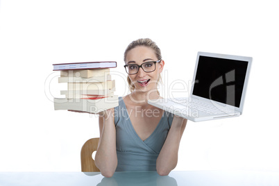 Junge Frau mit Laptop und Buch bei der Arbeit im Büro freigeste