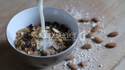 Pouring milk in a bowl with granola