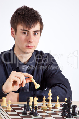 Young business man playing chess