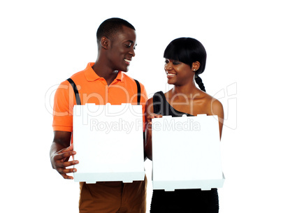 Loving couple holding pizza boxes