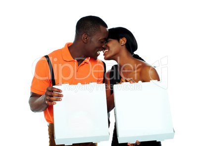 Black couple kissing and holding pizza boxes