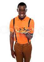 Smiling young african boy offering pizza