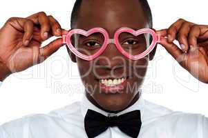 Smiling man wearing heart shaped eye-wear