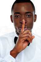 Black man showing silence gesture