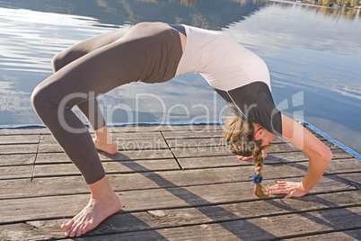 Junge Frau beim Yoga am See