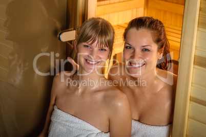 Two women at sauna wrapped in towel