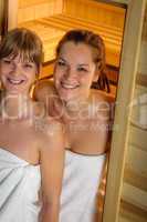 Two women at sauna wrapped in towel