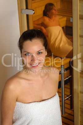 Women at sauna entering wrapped in towel