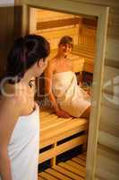 Women at sauna entering wrapped in towel