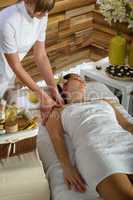 Woman shoulder massage at luxury spa centre
