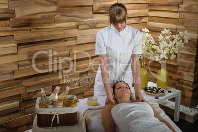 Woman enjoying neck massage at luxury spa