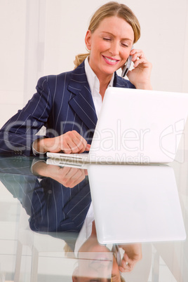 businesswoman in office with mobile and laptop