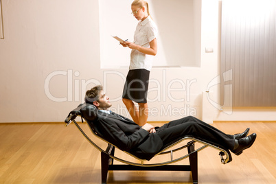 woman reading man lying on chaise longue