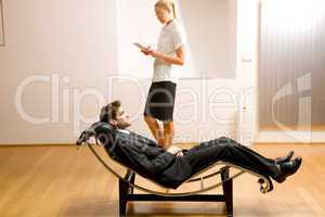 woman reading man lying on chaise longue