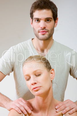 man massaging woman's shoulders