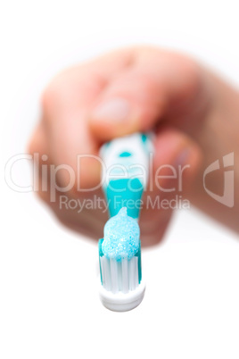 toothbrush with toothpaste in the hand