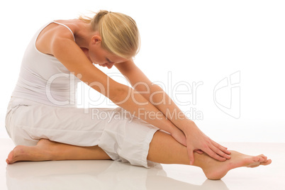 a young caucasian woman dressed in white sitting on the floor