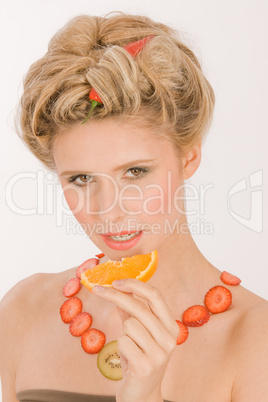 Attraktive blonde junge Frau mit Erdbeere-Kiwi- Kette