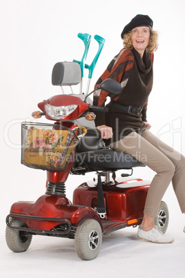 Behinderte ältere Frau mit Elektromobil