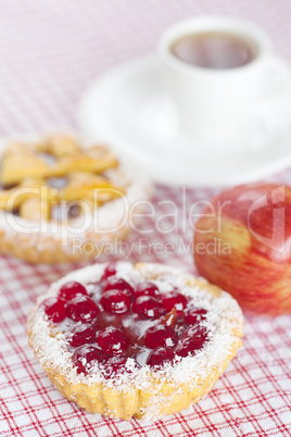 beautiful cake with berries,apple and tea on plaid fabric