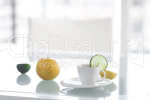cup of tea with tropical fruits on a glass surface