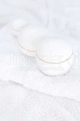 cosmetic containers lying on white towel