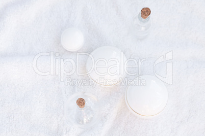cosmetic containers and  bottles on a white towel