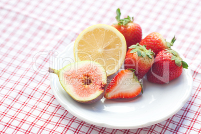 lemon, fig and strawberries on a plate