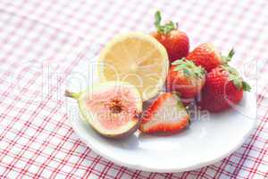 lemon, fig and strawberries on a plate