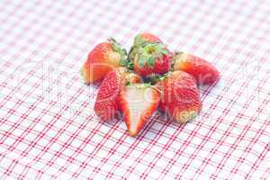 strawberry lying on plaid fabric