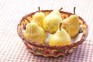 pears in a wooden basket  lying on a plaid fabric