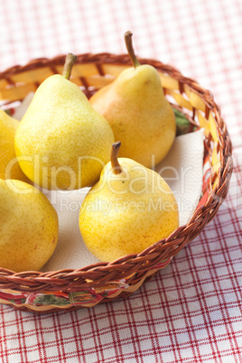 pears in a wooden basket  lying on a plaid fabric